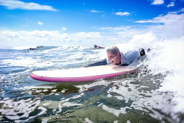 surfer peddelt voor een golf